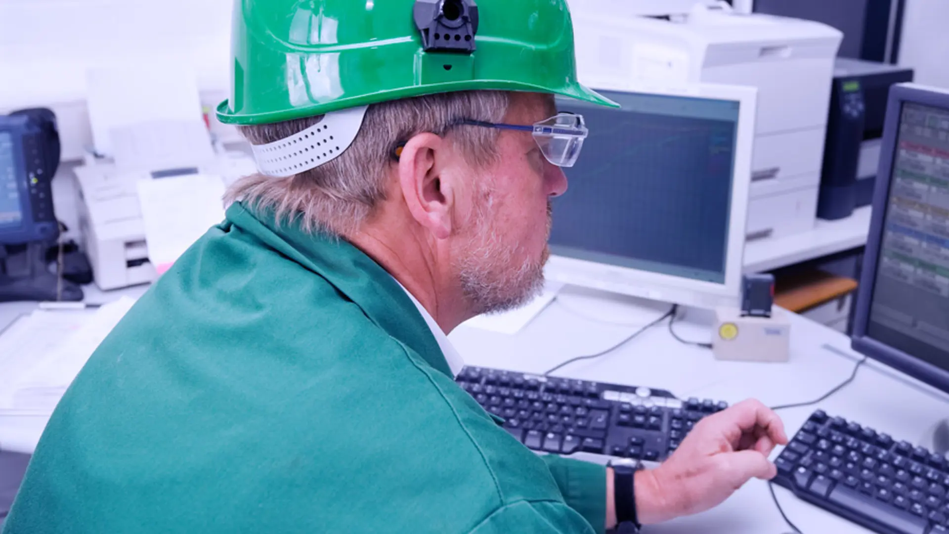 Shutterstock 19756861 Industrial Worker In His Office In Front Of A Pc